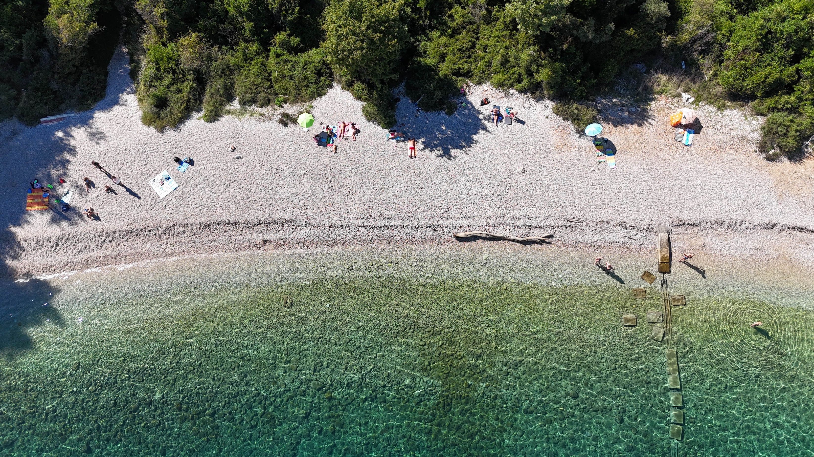 Clear shallows at Sveta Marina Pebble beach and transparent shallows seen directly from above