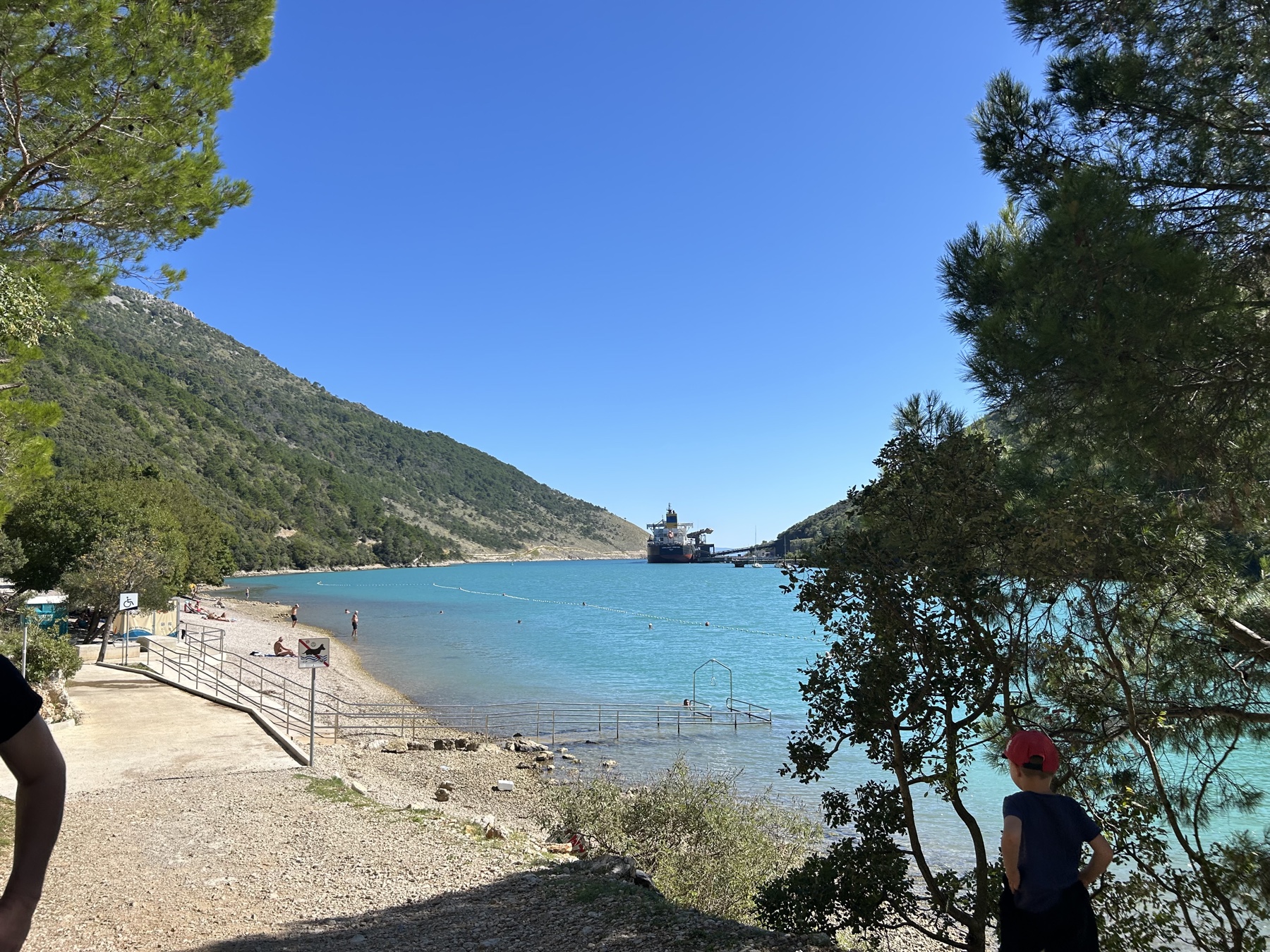 Stvarni industrijski pogled s Copacabane Šljunčana plaža Copacabana i mirno more s industrijskim građevinama na horizontu
