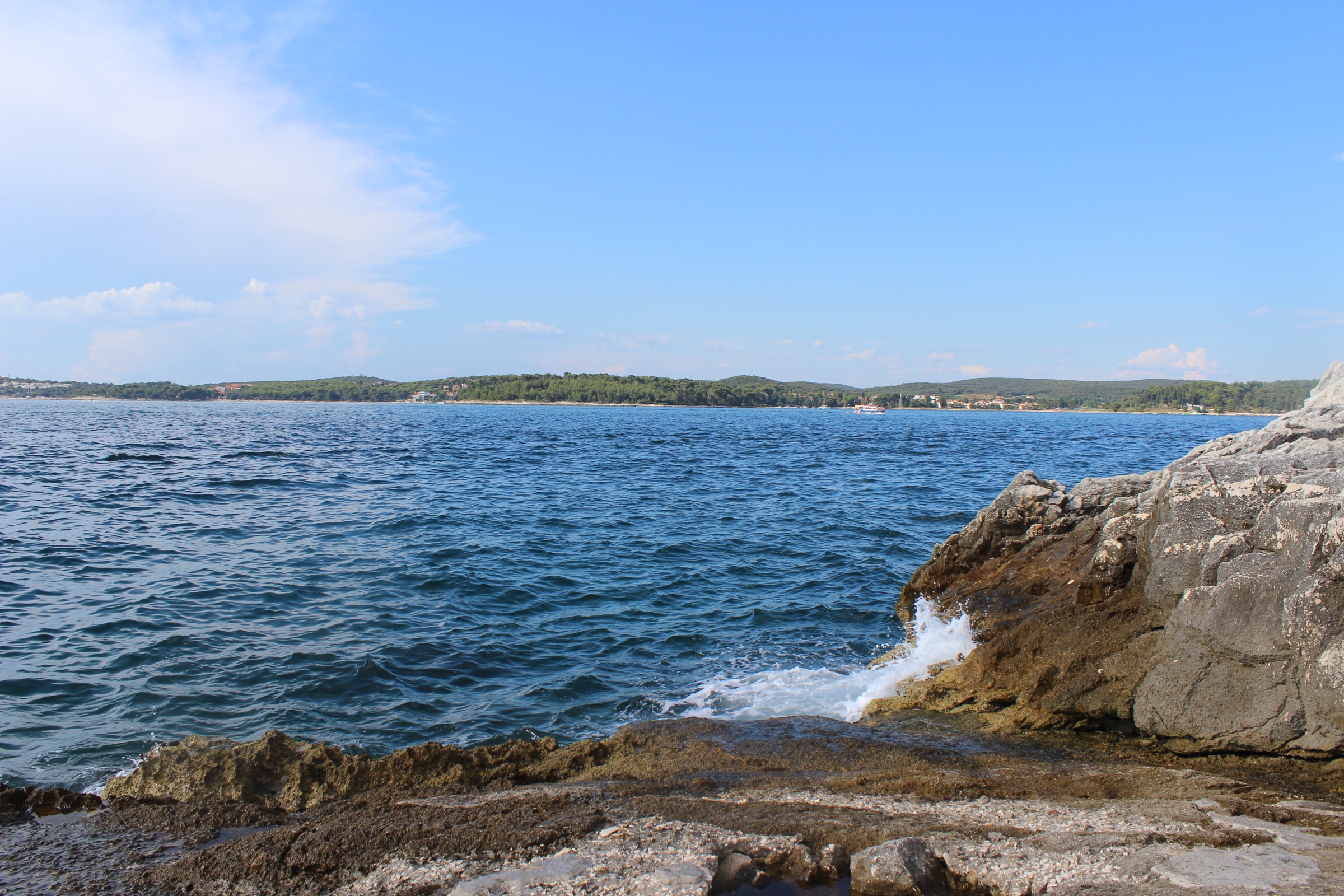 Vapnenac, voda i rub grada Izložena stjenovita obala i bistro Jadransko more uz Rovinj